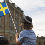 Liten kille i väntan med flagga