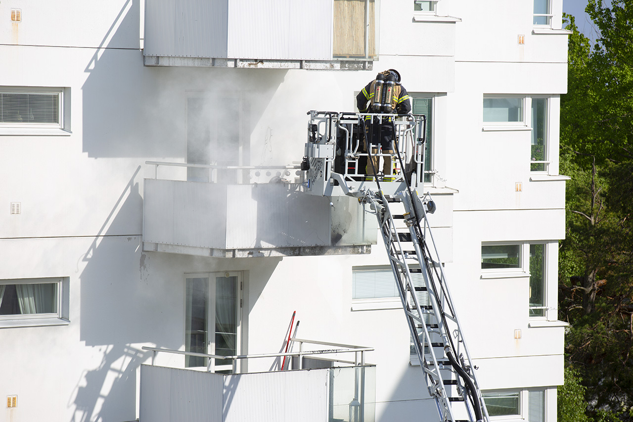 Brandman släcker med skumsläckare på en balkong.