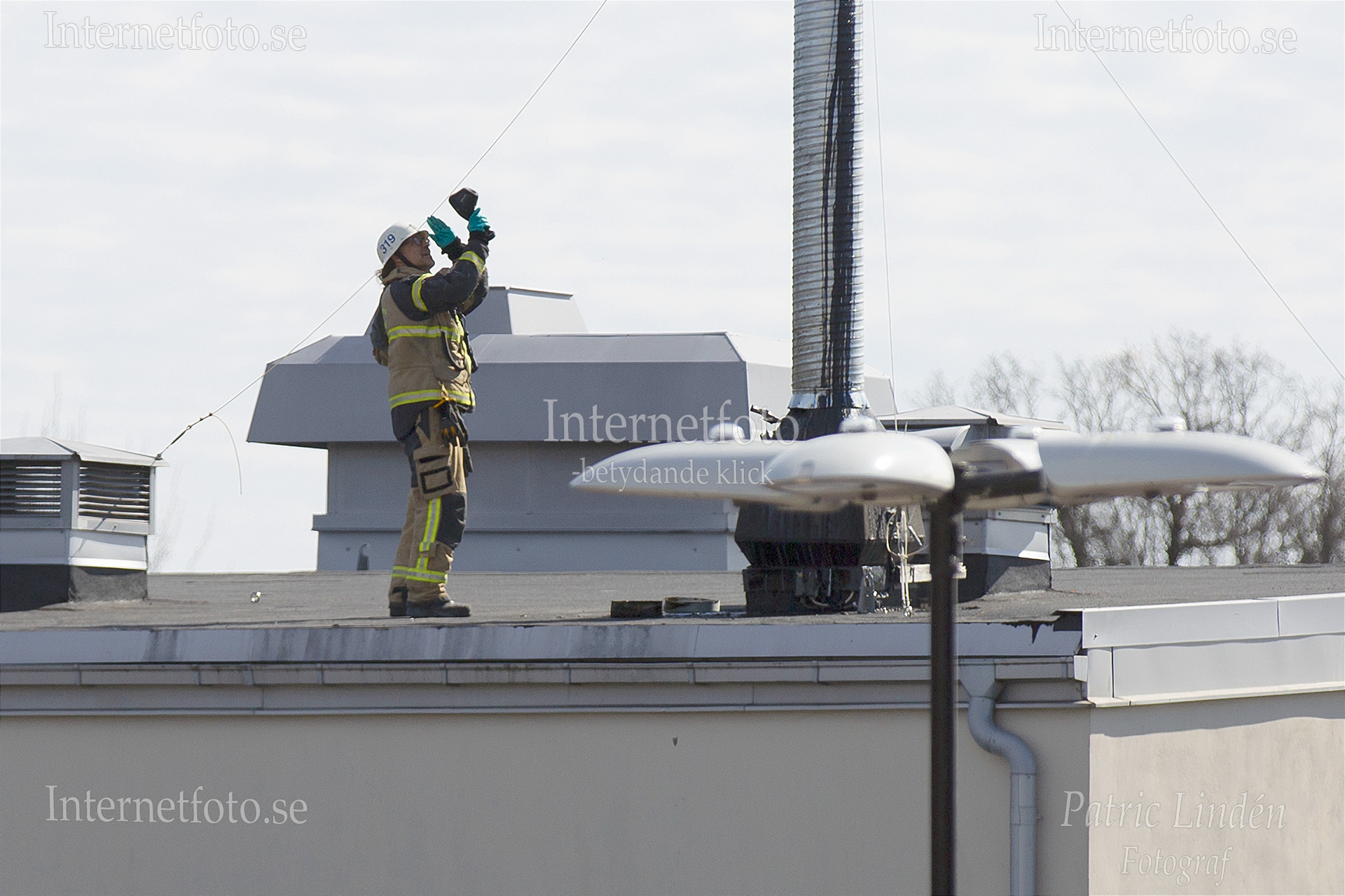 Brandman med IR-värmekamera på taket till Skärholmen Centrum.
